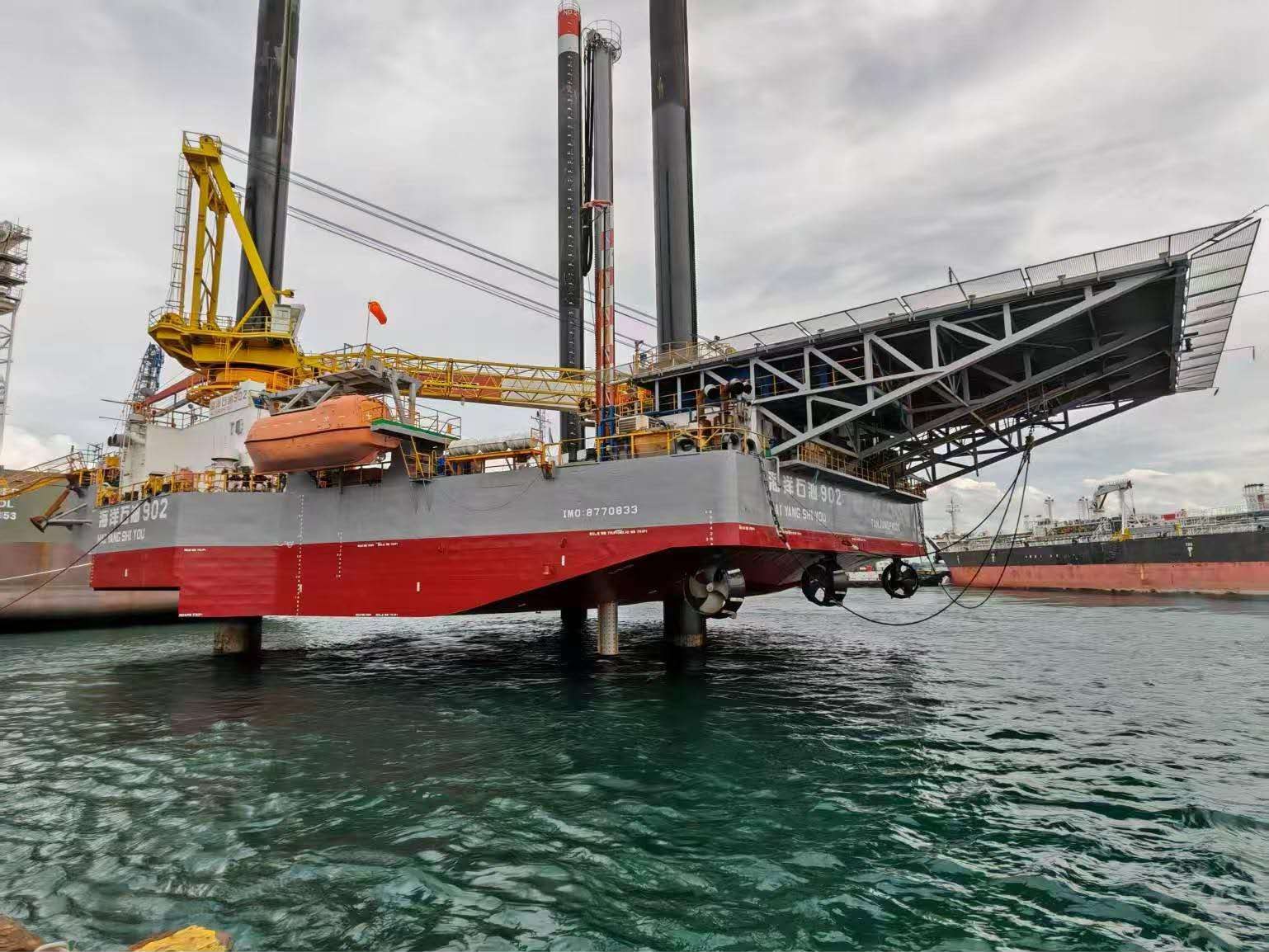 Self-elevating jack-up platform standing on its legs alongside a berth